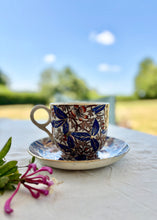 Load image into Gallery viewer, A large cup and saucer with botanical decoration