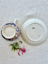 Load image into Gallery viewer, A large cup and saucer with botanical decoration