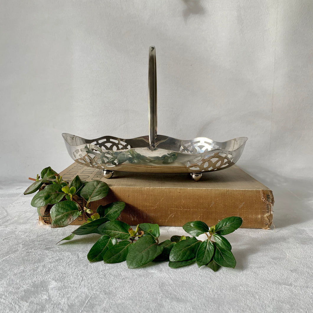 Decorative oval silver plate serving dish with hinged handle and cut-outs